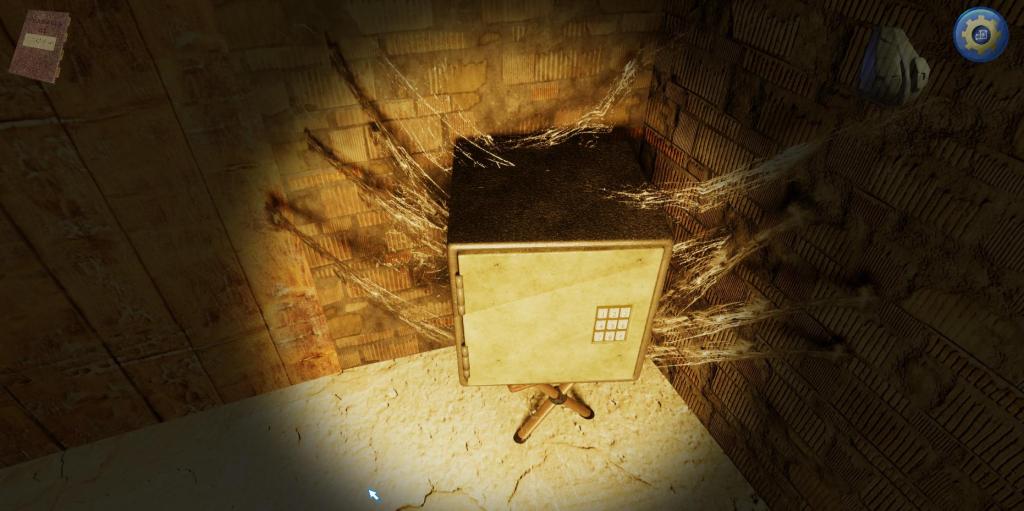 A safe sits in the corner of a brick room. The safe is covered in cobwebs.