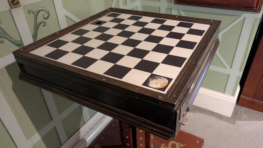 A checkered table on a wooden stand