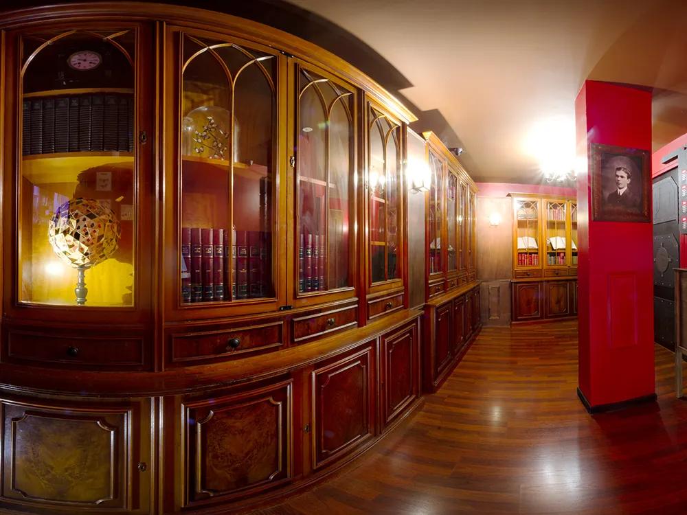 A library with various books and oddities behind glass and wooden shelving
