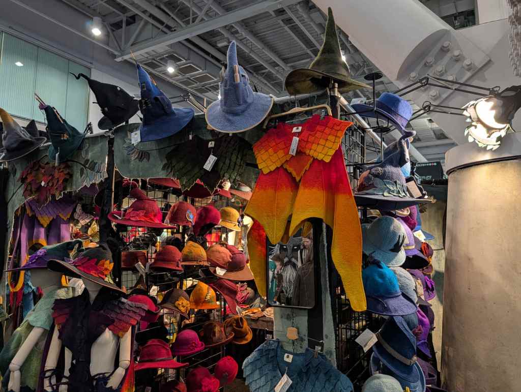 a stall displaying colorful felted costume items, mostly hats