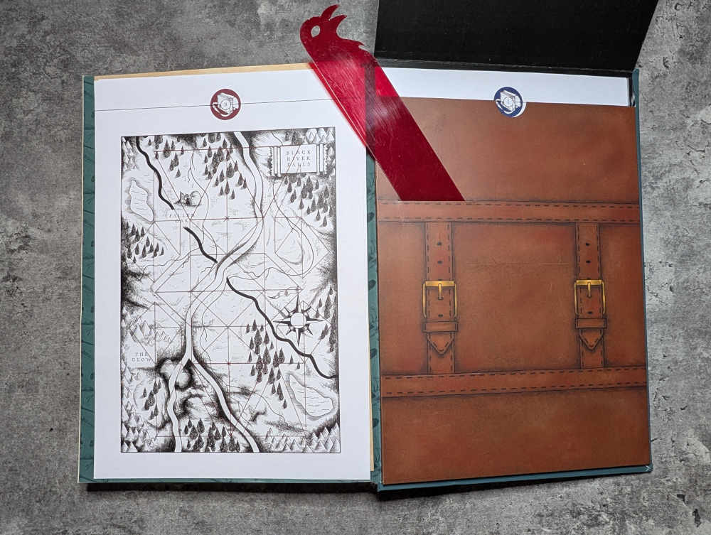 The back inside cover of the book The Stormlamp Rituals, showing a paper puzzle and the attached paper "satchel" that contains some puzzles.