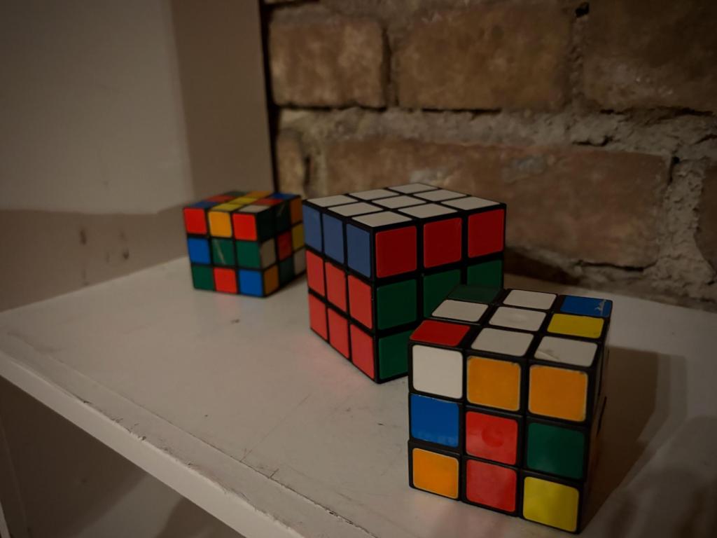 Image of three Rubik's cubes on a white shelf.