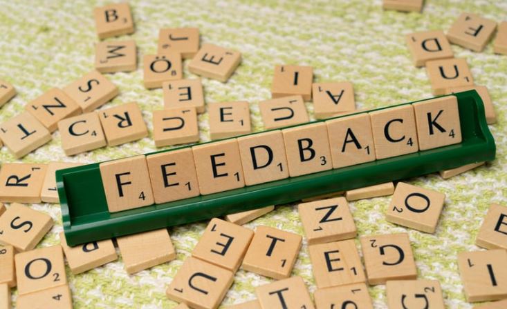scrabble tiles scattered around a display of tiles that read "feedback"