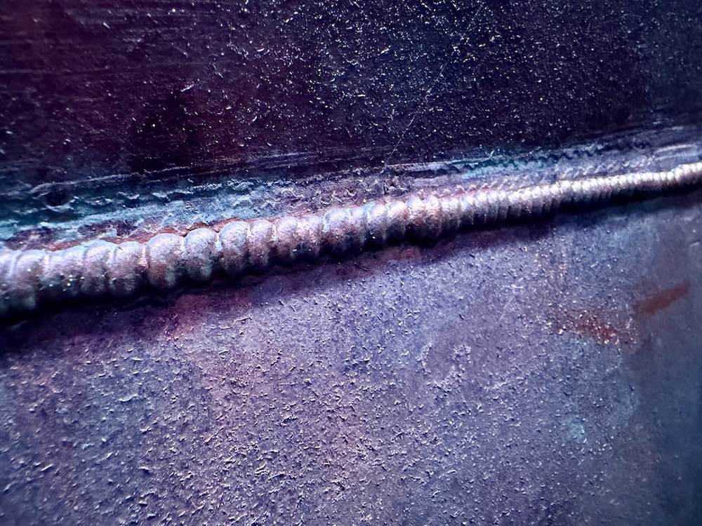 Closeup of a weld line made of glue adn painted to look like metal.