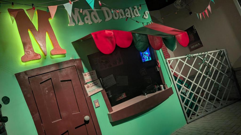 The cartoonish green facade to a restaurant labeled MadDonalds