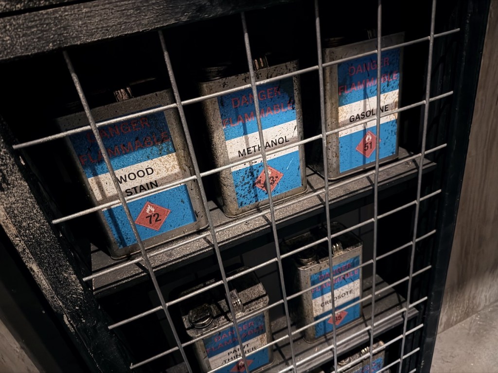 Closeup of a caged storage locker filled with flammable liquid containers.