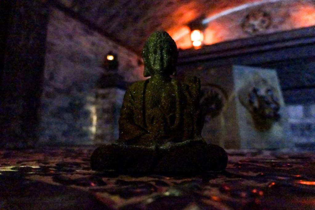 A buddha statue sitting in a stone tomb