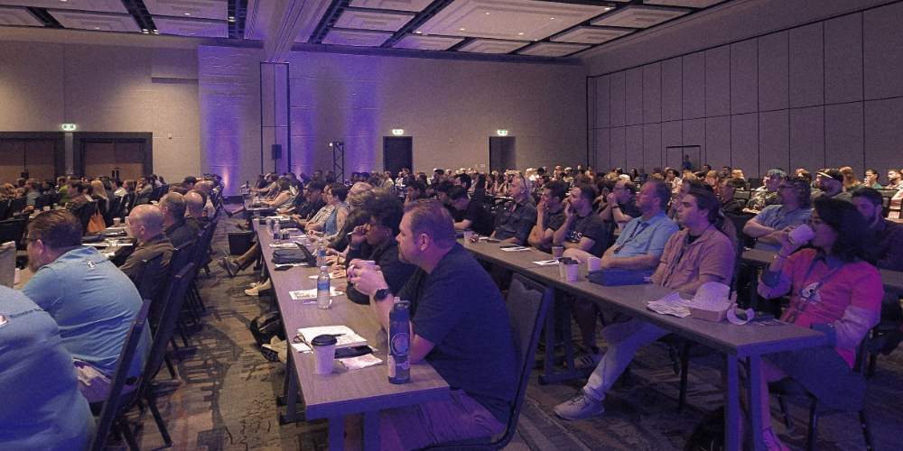 Photo of a group of people sitting in chairs listening to a someone speak at RECON Laval 26