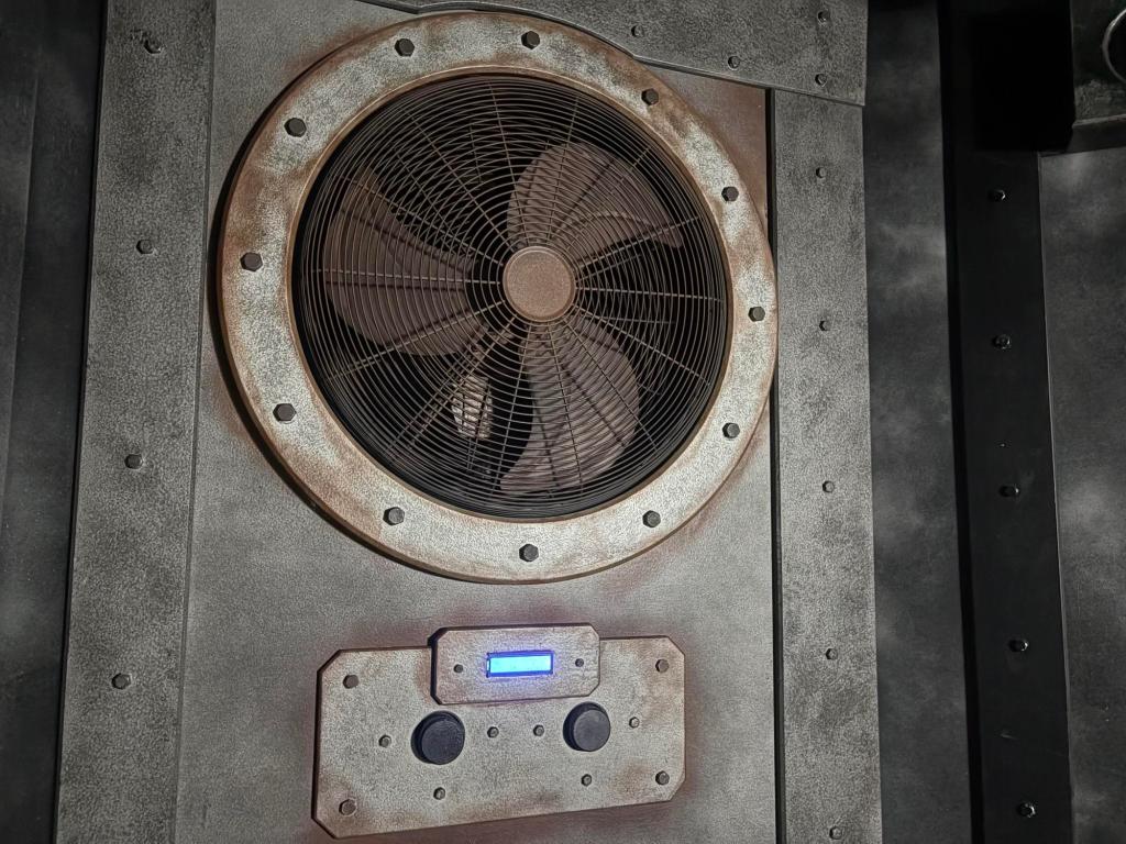 Closeup of a weathered exhaust fan with control dials below it.