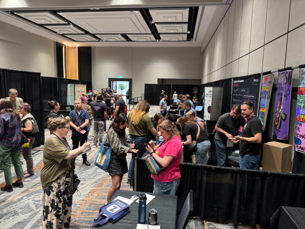 Image of people at the Impish exhibit hall booth during RECON 26.
