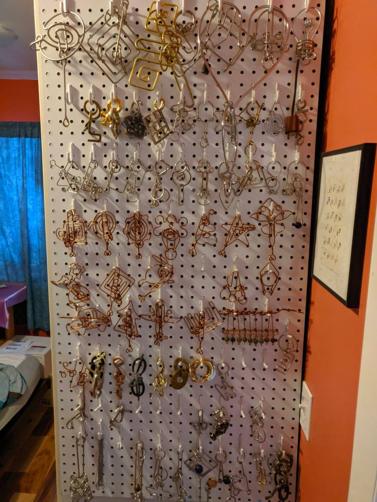 pegboard full of metal entanglement puzzles hanging