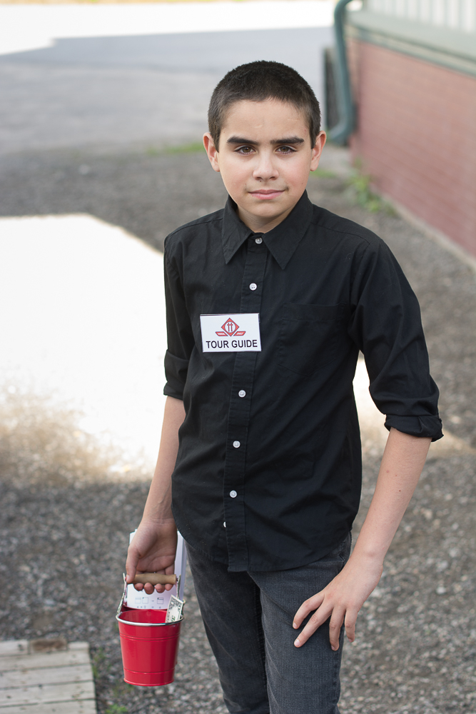 boy in button down shirt holding a little red bucket