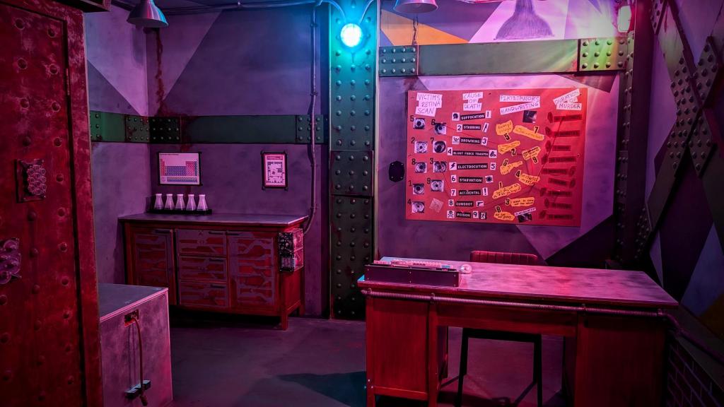 A room with a desk, a corkboard with lots of murder-related info, and green wall beams
