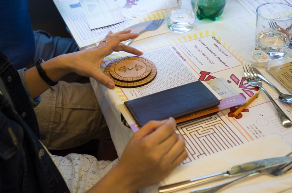 person solving puzzle on paper placemat